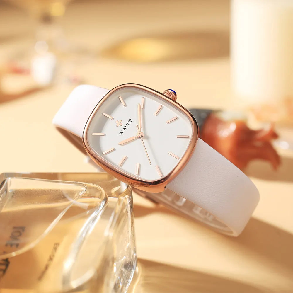 Relógio feminino com pulseira e fundo branco , mostrador dourado.